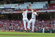 Cincinnati Reds' Eugenio Suarez, left, high-fives J.R. House, right, after hitting a solo home run during the third inning of a baseball game against the Minnesota Twins in Cincinnati, Tuesday, Aug. 3, 2021. (AP Photo/Aaron Doster)