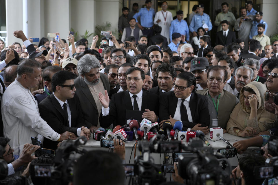 Chairman of Pakistan's Tehreek-e-Insaf party Gohar Khan, center, talks to the media while party supporters react after a Supreme Court decision in a case of reserved seats for women and minorities in parliament, in Islamabad, Pakistan, Friday, July 12, 2024. Pakistan's top court on Friday ruled that the party of imprisoned former Prime Minister Khan is eligible for seats reserved in the parliament, a major blow to the country's weak coalition government. (AP Photo/Anjum Naveed)