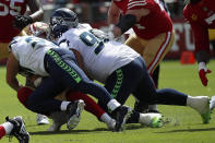 Seattle Seahawks linebacker Cody Barton, left, and defensive tackle Bryan Mone tackle San Francisco 49ers quarterback Trey Lance during the first half of an NFL football game in Santa Clara, Calif., Sunday, Sept. 18, 2022. Lance left the game after this play. (AP Photo/Josie Lepe)