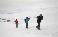 In this Friday, Jan. 24, 2020, photo, a group of snowboarders hike up the snow-covered hillside known as Kohe Koregh, on the outskirts of Kabul, Afghanistan. While Afghanistan’s capital may seem an unlikely destination for snowboarders, a group of young Afghans is looking to put the city on the winter sports map and change perceptions about their war-weary nation. (AP Photo/Rahmat Gul)