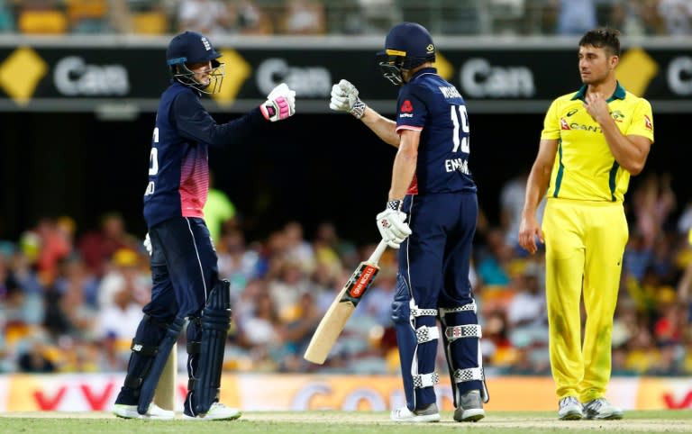 England's Joe Root (L) and Chris Woakes (C) celebrate the team's victory as Australia's Marcus Stoinis looks on during the second one-day international in Brisbane on January 19, 2018