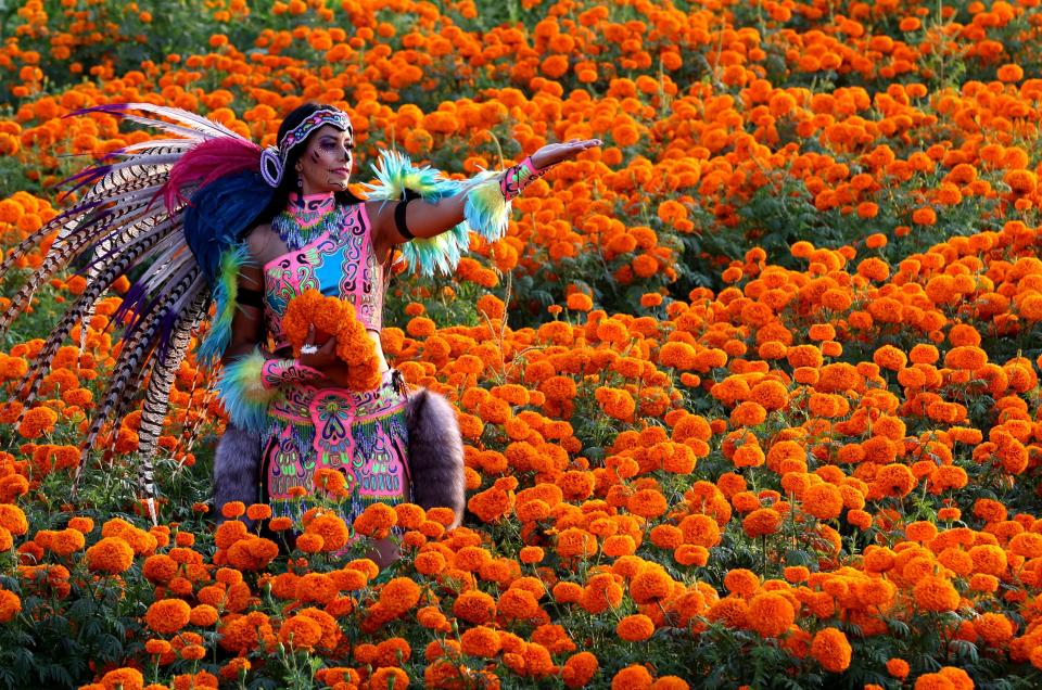 A woman dressed as a pre-Hispanic Catrina poses on Oct. 26, 2023 for a photograph in a field of Cempazuchitl flowers - Mexican Marigold (Tagetes erecta) - as part of the preparations for the Day of the Dead celebration in Tlajomulco de Zuñiga, Jalisco state, Mexico.