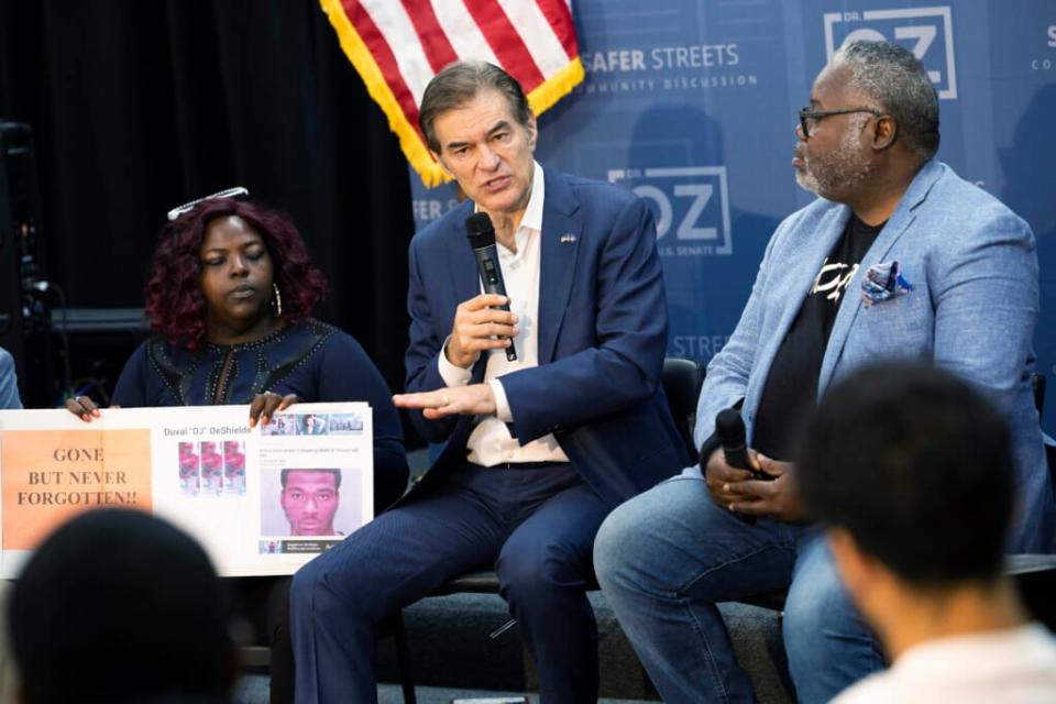 Sheila Armstrong (left) and Mehmet Oz (center) appear together at the Philadelphia gun violence event last month where at one point the Pennsylvania Republican candidate for the U.S. Senate consoled the grieving woman. At the time, reporters were not aware that Armstrong is an Oz campaign aide. (AP Photo/Ryan Collerd, File)