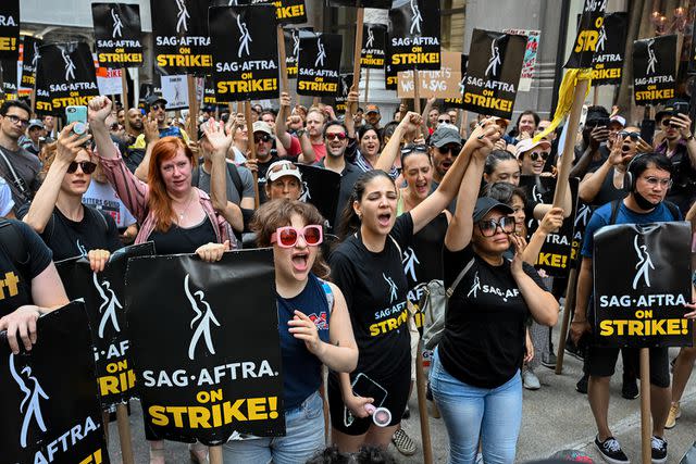 <p>Alexi Rosenfeld/Getty</p> Members of the Writers Guild of America and SAG-AFTRA strike in N.Y.C.