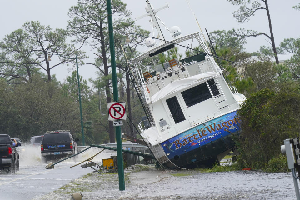 A boat is washed up near a road after Hurricane Sally moved through the area, Wednesday, Sept. 16, 2020, in Orange Beach, Ala. Hurricane Sally made landfall Wednesday near Gulf Shores, Alabama, as a Category 2 storm, pushing a surge of ocean water onto the coast and dumping torrential rain that forecasters said would cause dangerous flooding from the Florida Panhandle to Mississippi and well inland in the days ahead. (AP Photo/Gerald Herbert)