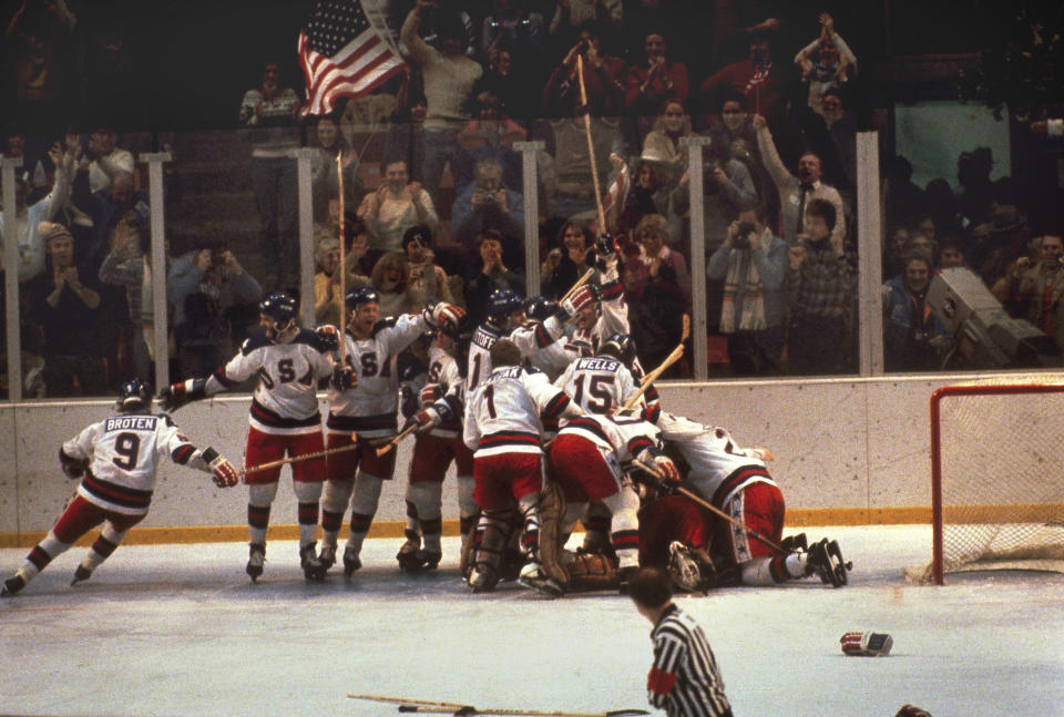 <p>Team USA piled onto goalie Jim Craig in celebration of their improbable 4-3 win over the Soviets to advance to the gold medal game. Fittingly, a fan in the stands behind them waved an American flag. </p>