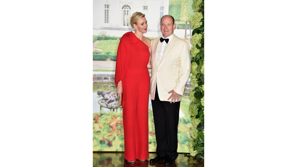 Princess Charlene in a fiery red jumpsuit with Prince Albert