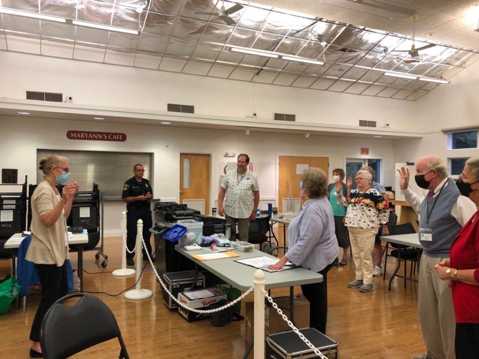 Wellfleet Town Clerk Jennifer Congel swears in poll workers just before 7 a.m. Tuesday morning at the Council on Aging.