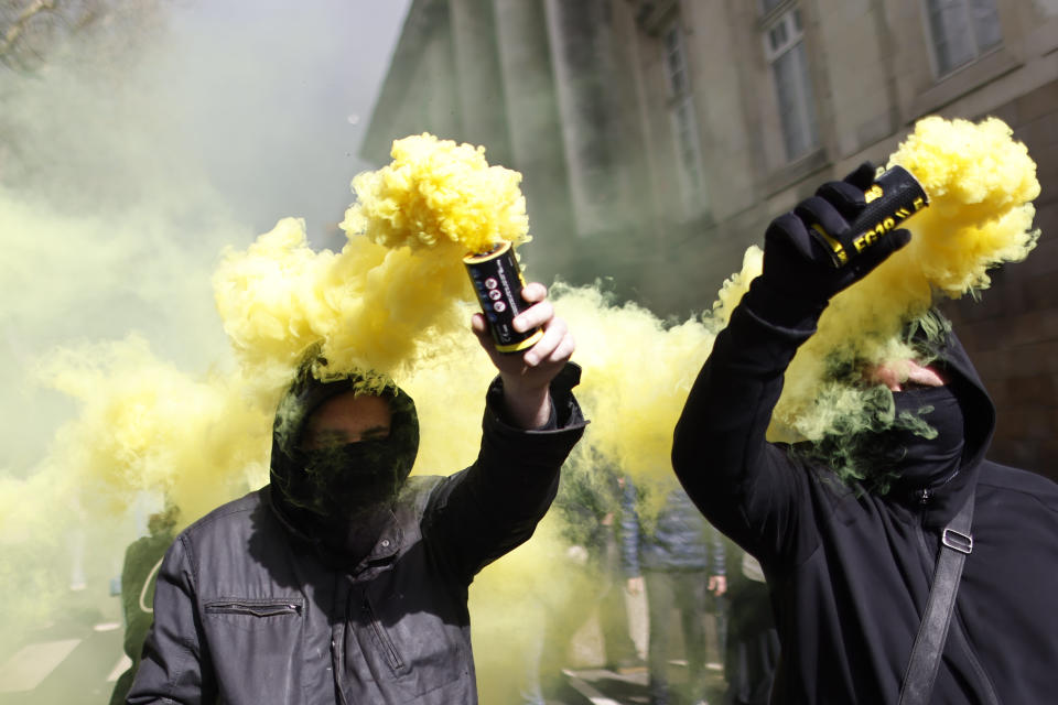 Protesters march with flares during a demonstration in Nantes, western France, Saturday, March 18, 2023. A spattering of protests are planned to continue in France over the weekend against President Emmanuel Macron's controversial pension reform. (AP Photo/Jeremias Gonzalez)