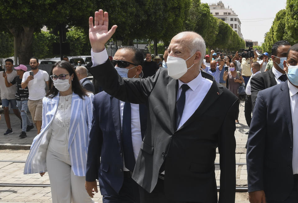 Tunisian President Kais Saied waves to bystanders as he stroll along the avenue Bourguiba in Tunis, Tunisia, Sunday, Aug. 1, 2021. President Kais Saied claimed on Sunday that some desperate youth are being paid to try to leave Tunisia illegally for Europe, saying the goal is to damage the country from within. (Slim Abid/Tunisian Presidency via AP)