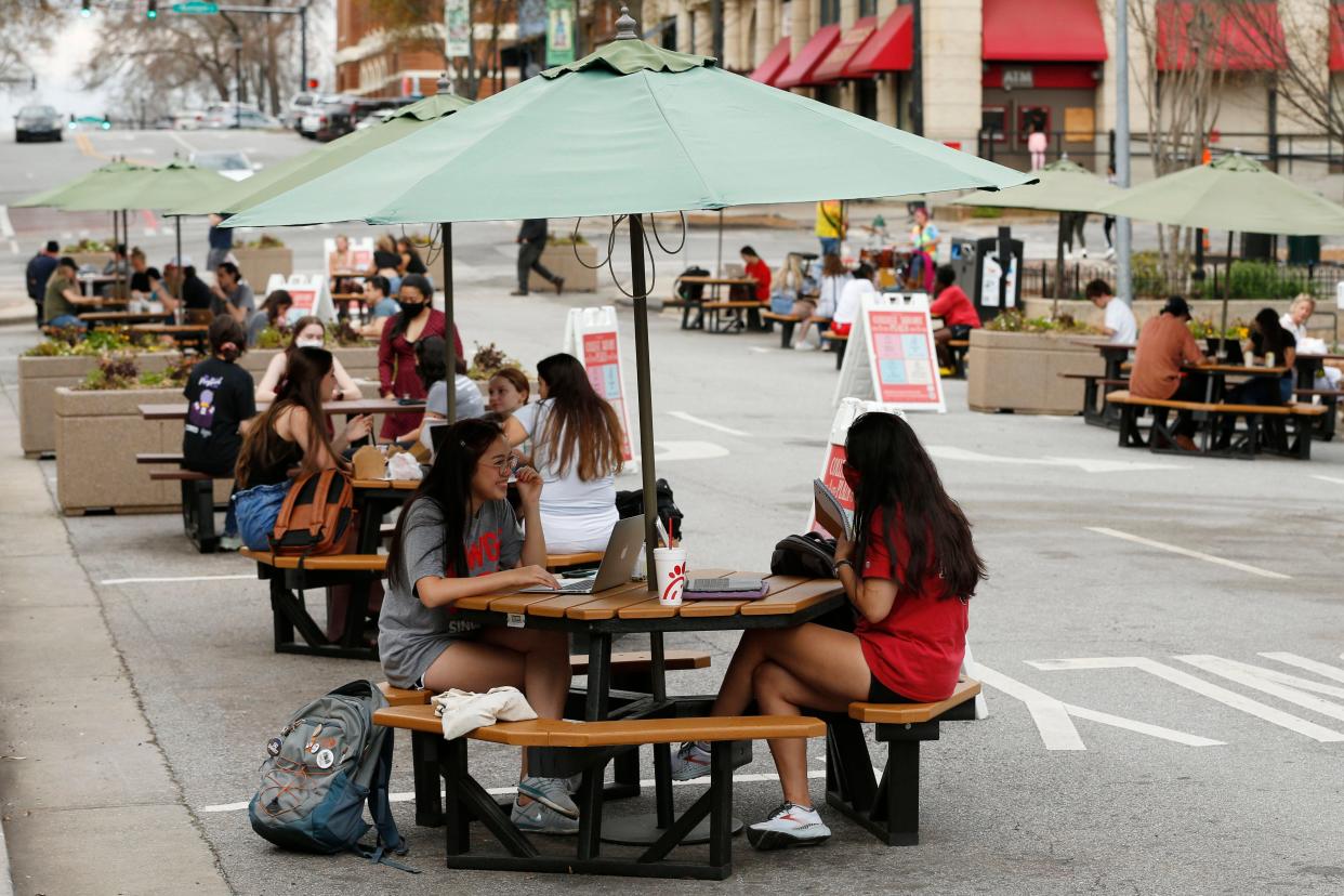 FILE - People enjoy the spring weather at the College Square parklet in downtown Athens, Ga., on Friday, March 19, 2021. The ACC commissioners approved expanding the parklets to all eligible restaurants or specialty shops throughout downtown Athens.
