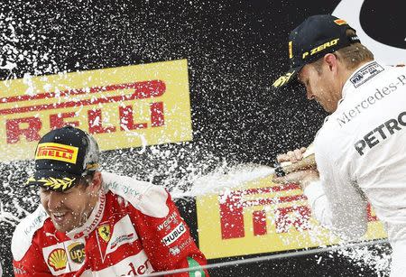 Formula One - Chinese F1 Grand Prix - Shanghai, China - 17/4/16 - Mercedes Formula One driver Nico Rosberg of Germany (R) and Ferrari Formula One driver Sebastian Vettel of Germany after the Chinese Grand Prix. REUTERS/Aly Song