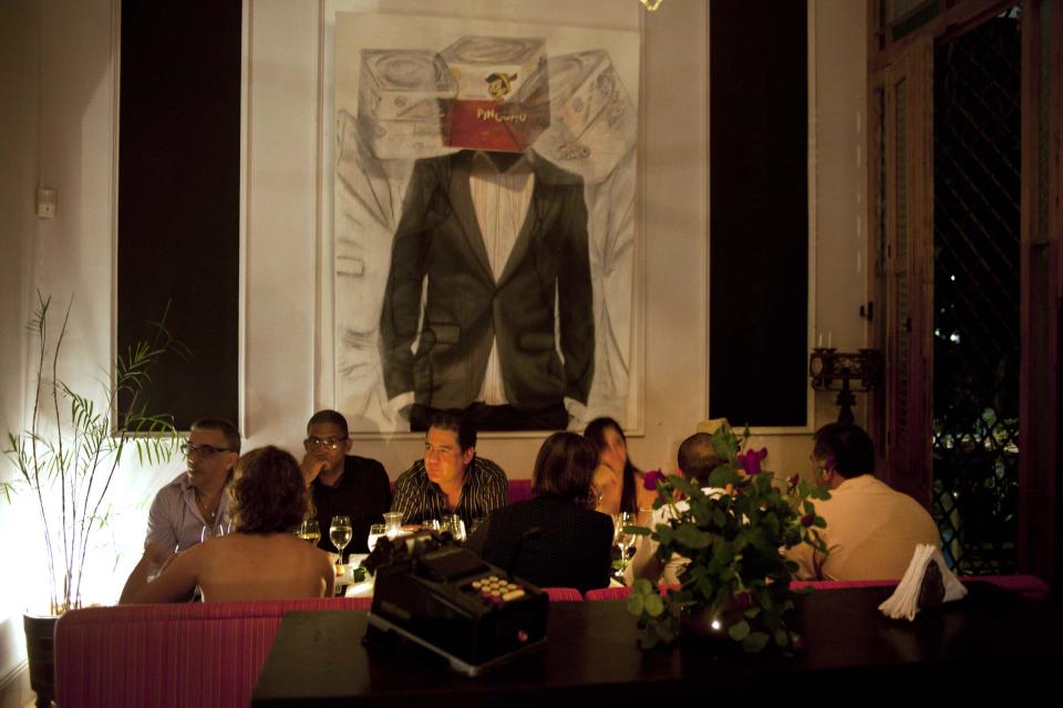 In this Dec. 7, 2012 photo, people eat a dinner prepared by chefs from the U.S. "Planting Seeds" delegation at the private restaurant Le Chansonnier in Havana, Cuba. The U.S. chefs held give-and-take seminars with chefs and culinary students about slow food. Cuba's President Raul Castro has moved to expand private and cooperative agriculture, lease out fallow state land and facilitate direct sales to state- and private-run eateries. (AP Photo/Ramon Espinosa)