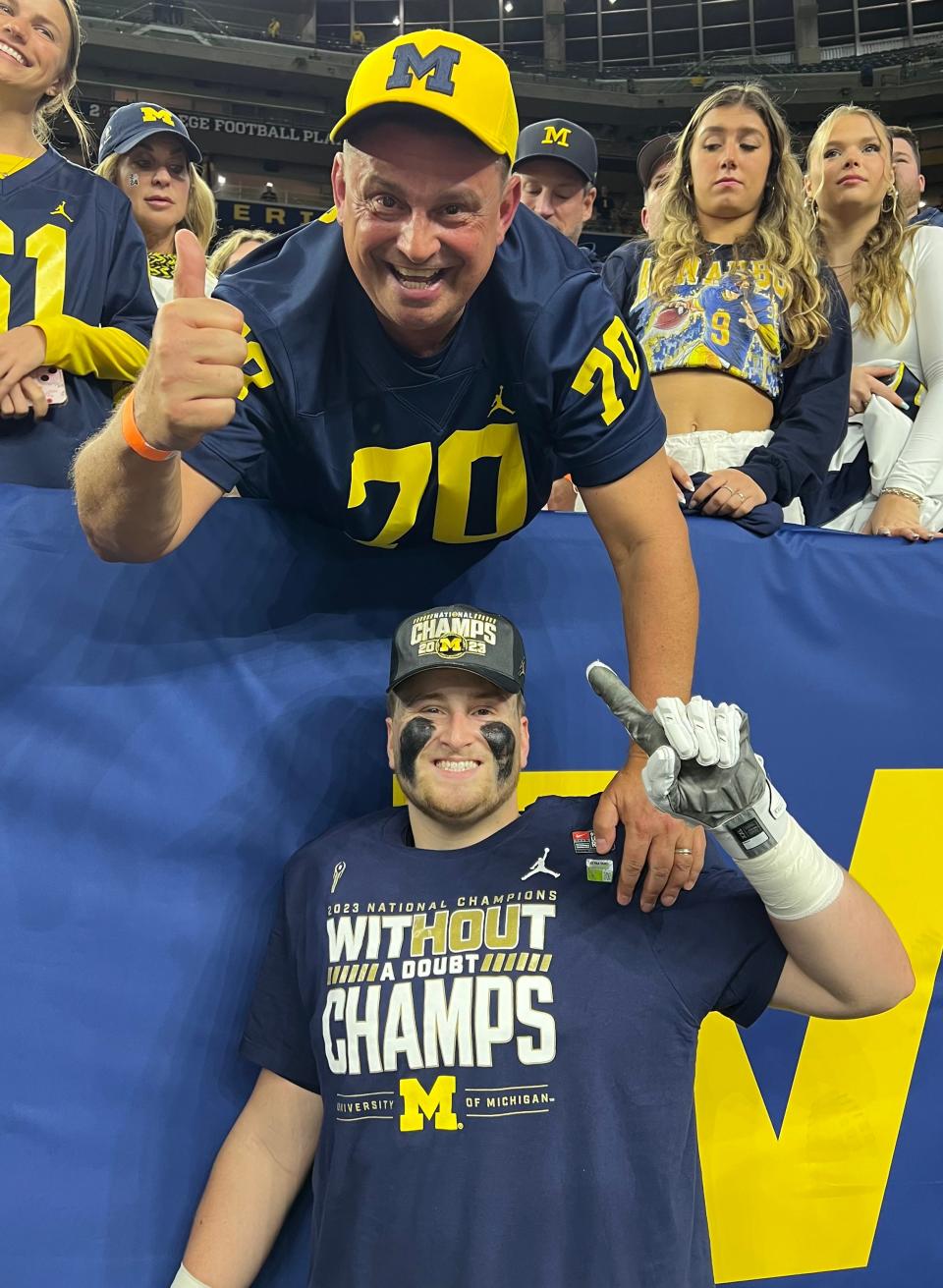 Peter Simmons Sr. celebrates with his son, Peter Simmons III, following Michigan's 34-13 win over No. 2 Washington in the CFP National Championship