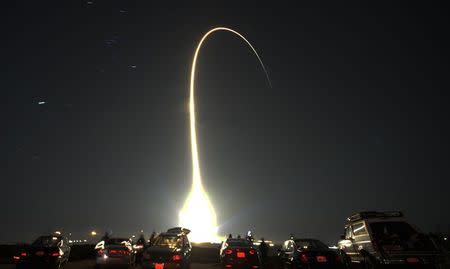 People watch as a United Launch Alliance Atlas V rocket, carrying a classified payload from the U.S. government's National Reconnaissance Office, lifts-off at the Vandenberg Air Force Base, California, in this December 5, 2013 file photo. REUTERS/Gene Blevins/Files