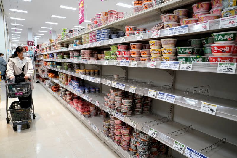 FILE PHOTO: A shopper wearing a protective mask looks at shelves at a supermarket in Tokyo