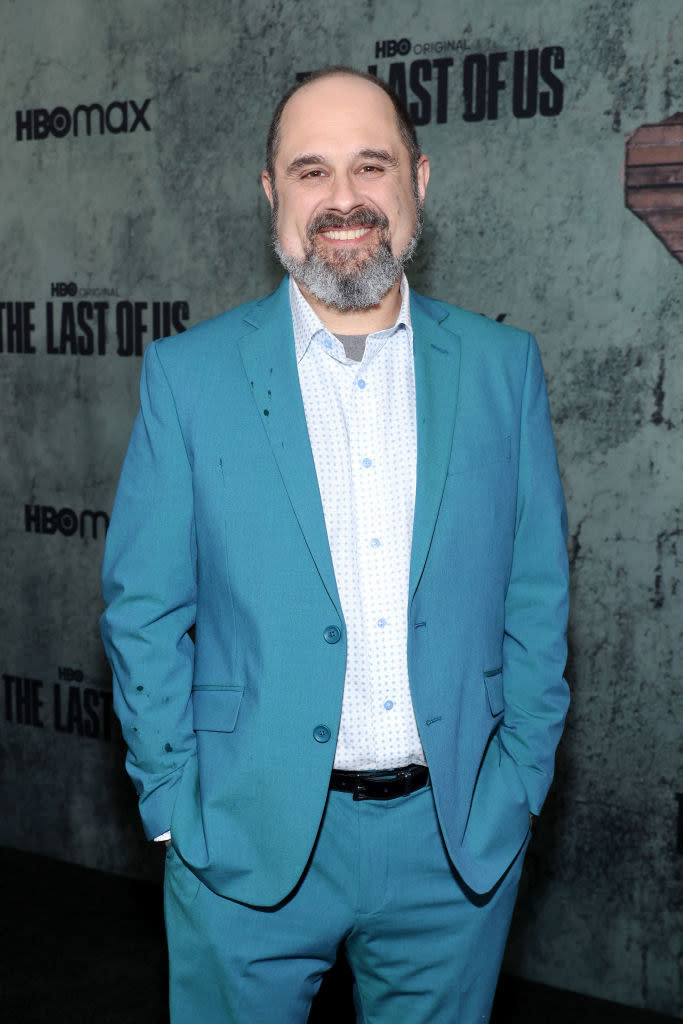 Craig smiles at a red carpet event for The Last of Us. He's wearing a suit and smiling with his hands in his pocket