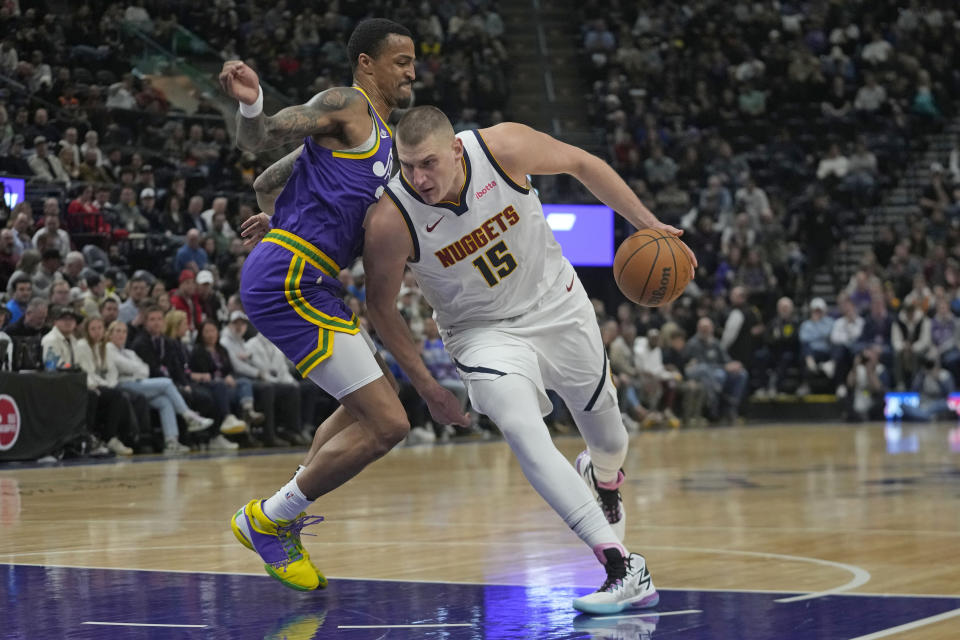 Denver Nuggets center Nikola Jokic (15) drives as Utah Jazz forward John Collins (20) defends during the first half of an NBA basketball game Wednesday, Jan. 10, 2024, in Salt Lake City. (AP Photo/Rick Bowmer)