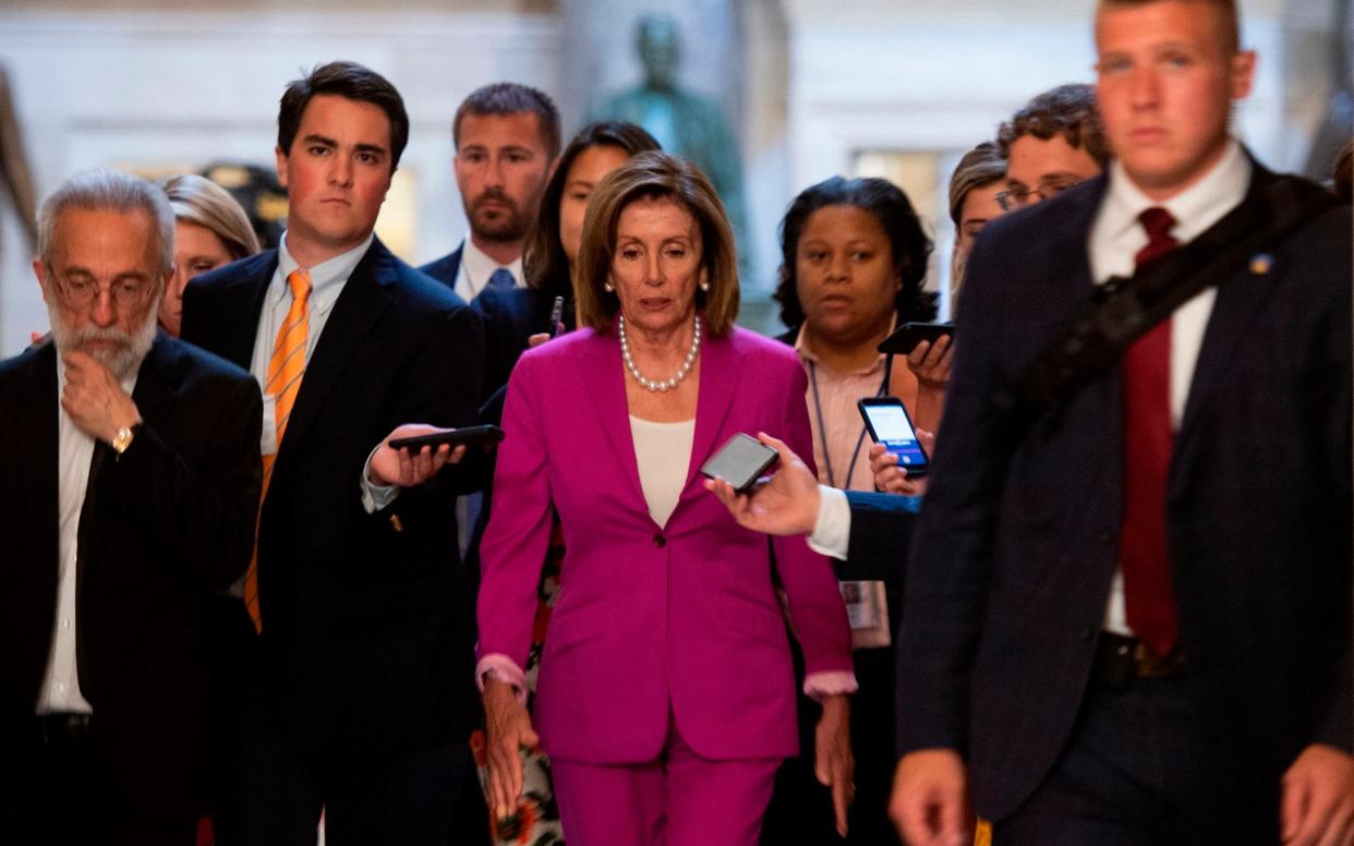 US speaker of the House, Nancy Pelosi (C) walks with reporters, before the Democrat controlled House of Representatives passed a resolution condemning US President Donald Trump for his 