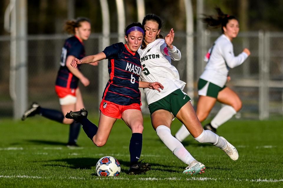 Mason's Mya Carnevale, left, kicks the ball as Williamston's Ella Kleiver closes in during the first half on Wednesday, May 3, 2023, in Mason.