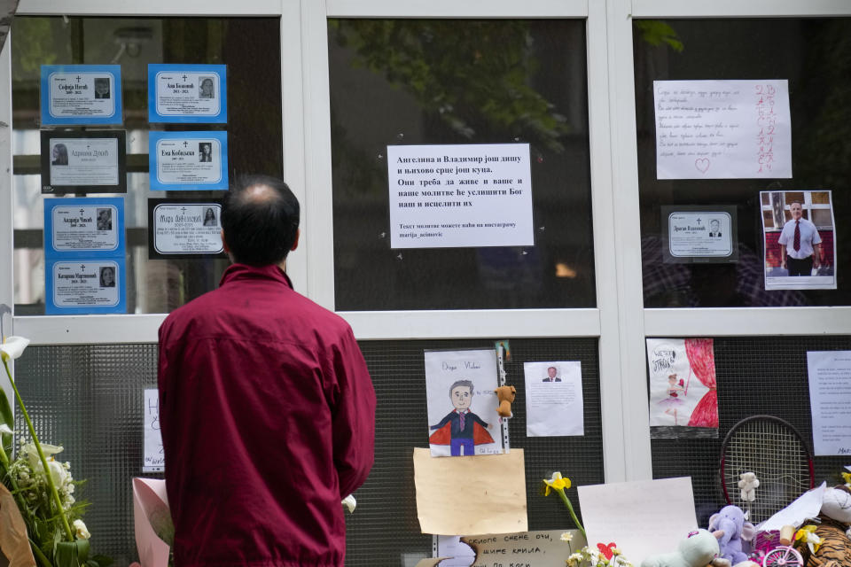 A man reads death notices of victims of a shooting in the Vladimir Ribnikar school in Belgrade, Serbia, Monday, May 8, 2023. Police on Monday deployed in schools throughout Serbia in an effort to restore a shaken sense of security following two mass shootings last week - including one in a primary school in Belgrade - that left 17 people dead and 21 wounded, many of them children. (AP Photo/Darko Vojinovic)