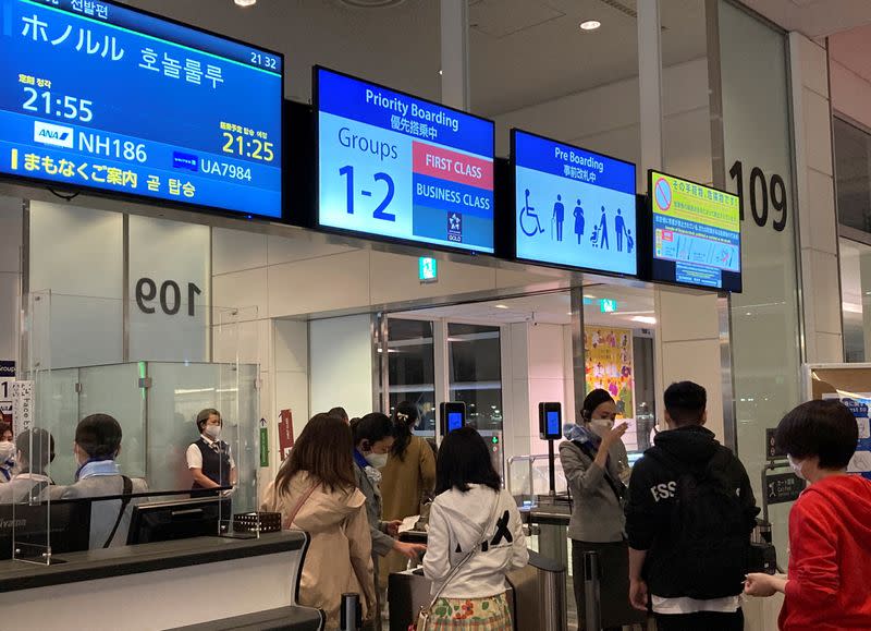 Travelers line up to board a Hawaii-bound flight from Tokyo's Haneda International Airport during Japan's "Golden Week" holidays, in Tokyo