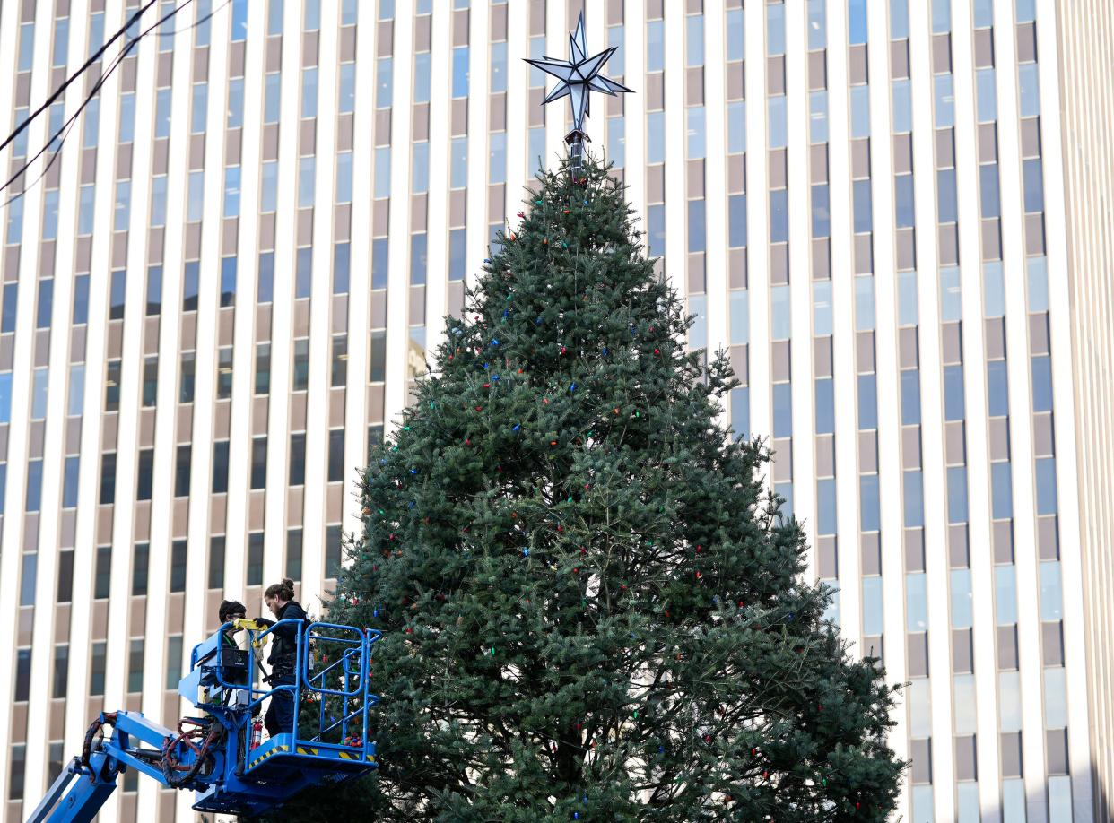 Lights were placed around the 55-foot fir tree making its home at Fountain Square on Monday.