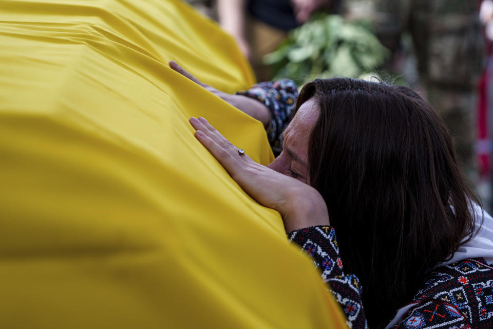 A woman cries over the coffin of Ukrainian journalist and volunteer combat medic Iryna Tsybukh during a memorial service on Independence square in Kyiv, Ukraine, Sunday, June 2, 2024. Nearly 1,000 people attended a ceremony Sunday honoring the memory of Ukrainian journalist Iryna Tsybukh, who was killed in action while serving as a combat medic a few days before her 26th birthday. Tsybukh was killed while on rotation in Kharkiv area, where Russia started its offensive nearly a month ago. (AP Photo/Evgeniy Maloletka)