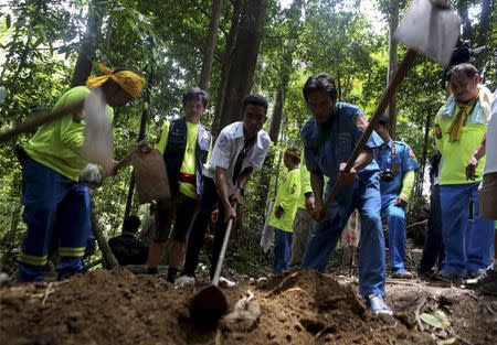 Rescue workers inspect a mass grave at an abandoned camp in a jungle in Thailand's southern Songkhla province May 5, 2015. REUTERS/Surapan Boonthanom