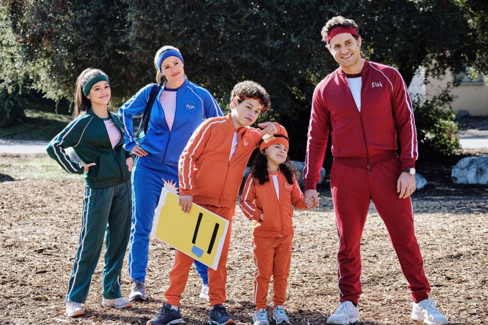 the family dressed in their team colors outside to play