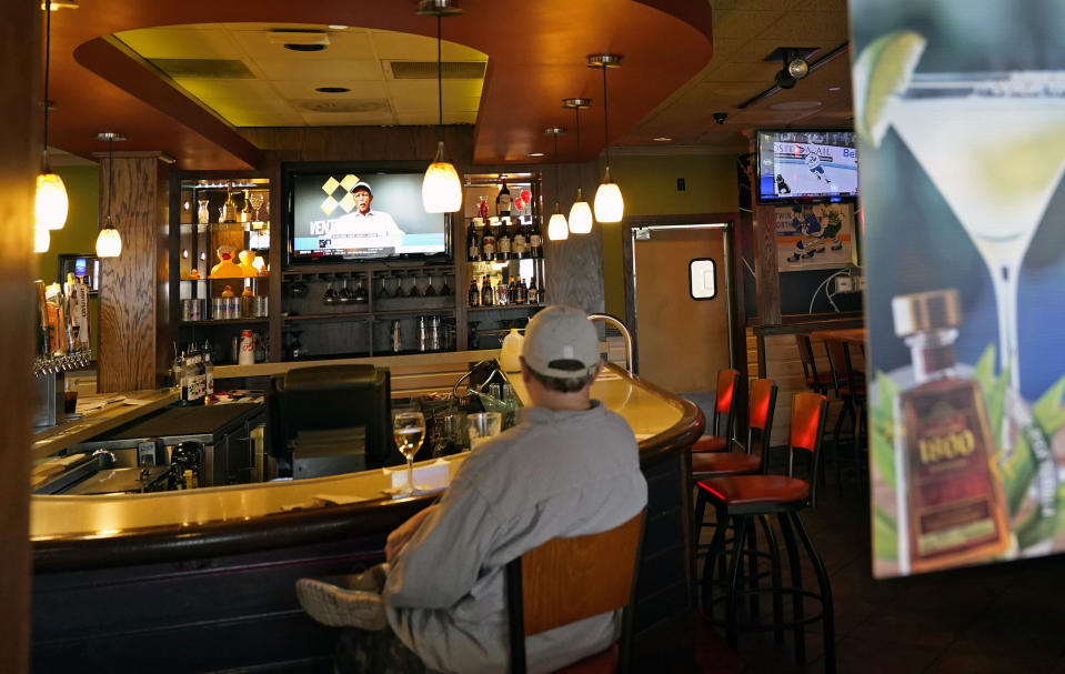 FILE - In this Nov. 10, 2020, a customer sits at a bar at a Bloomington, Minn., restaurant. Minnesota Gov. Tim Walz announced restrictions that bars and restaurants will be required to end dine-in service between 10 p.m. and 4 a.m., beginning Friday in an effort to slow the spread of the COVID-19. (AP Photo/Jim Mone, File)