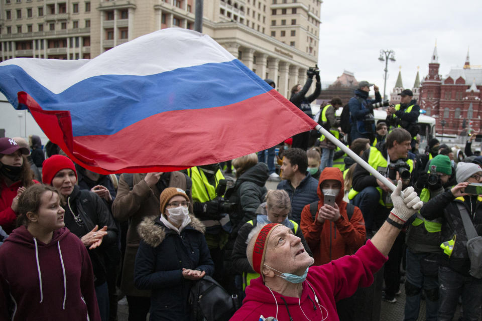 A supporter waves the Russian national flag and shouts slogans during the opposition rally in support of jailed opposition leader Alexei Navalny in the center of Moscow near Red Square, Russia, Wednesday, April 21, 2021. Police across Russia have detained large numbers of people in connection with demonstrations in support of imprisoned opposition leader Alexei Navalny, according to a human rights group. (AP Photo/Alexander Zemlianichenko)