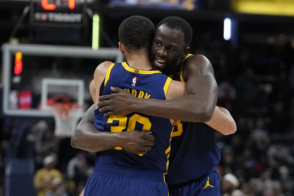 Golden State Warriors' Draymond Green hugs Stephen Curry (30) during the second half of an NBA basketball game against the Indiana Pacers, Thursday, Feb. 8, 2024, in Indianapolis. (AP Photo/Darron Cummings)