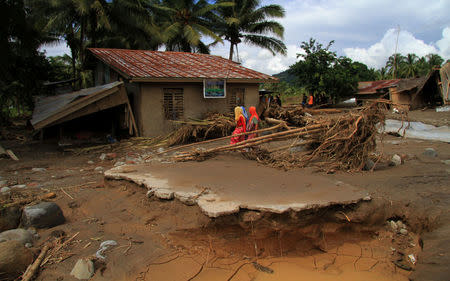 Residents walk in a village devastated by flash floods in Salvador, Lanao del Norte in southern Philippines, December 24, 2017. REUTERS/Richel V. Umel