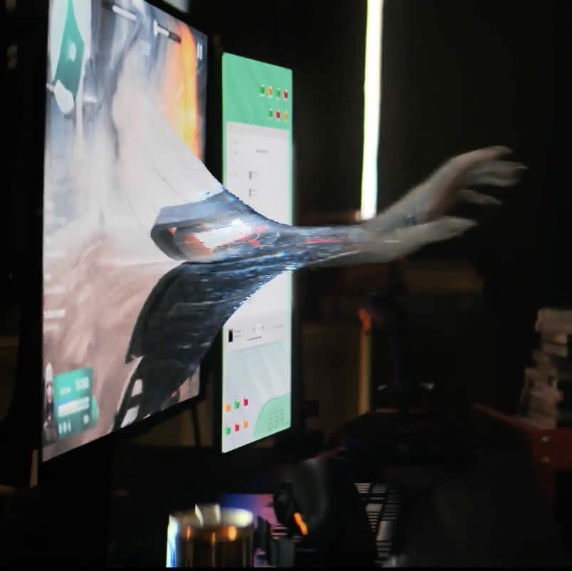 Blurry image of a person throwing papers, with a computer screen in the background and a hand coming through it