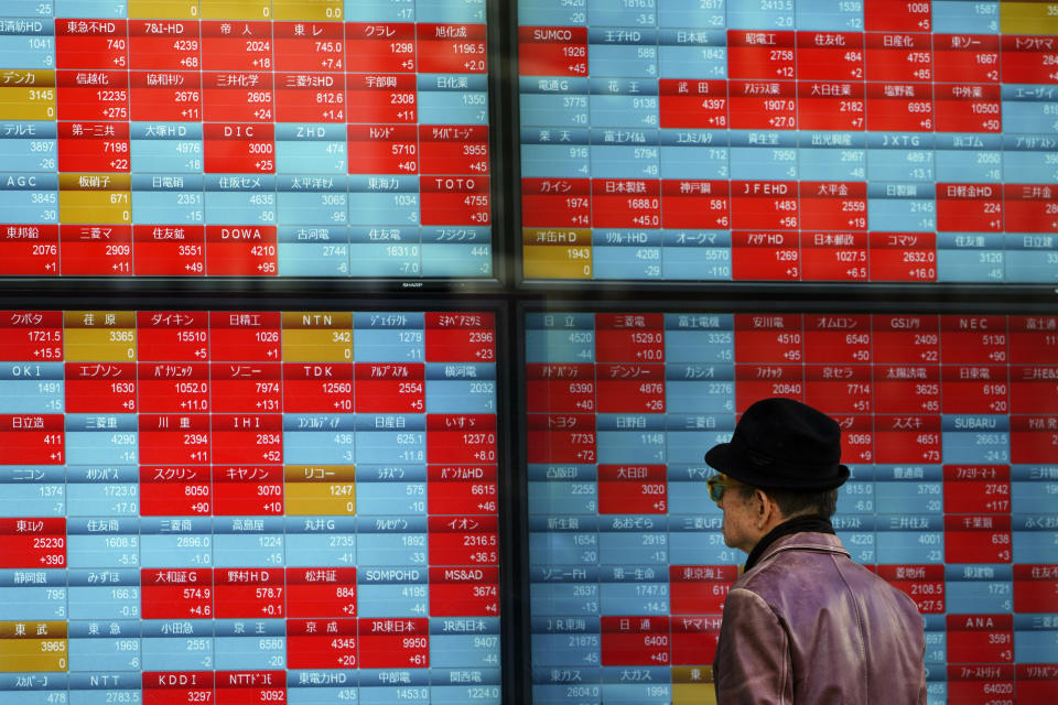 In this Jan. 14, 2020, photo, a man looks at an electronic stock board showing Japan's Nikkei 225 index at a securities firm in Tokyo Tuesday, Jan. 14, 2020. Asian shares followed Wall Street higher on Tuesday amid optimism that a trade deal between the U.S. and China will be a boon for the regional economy. (AP Photo/Eugene Hoshiko, File)