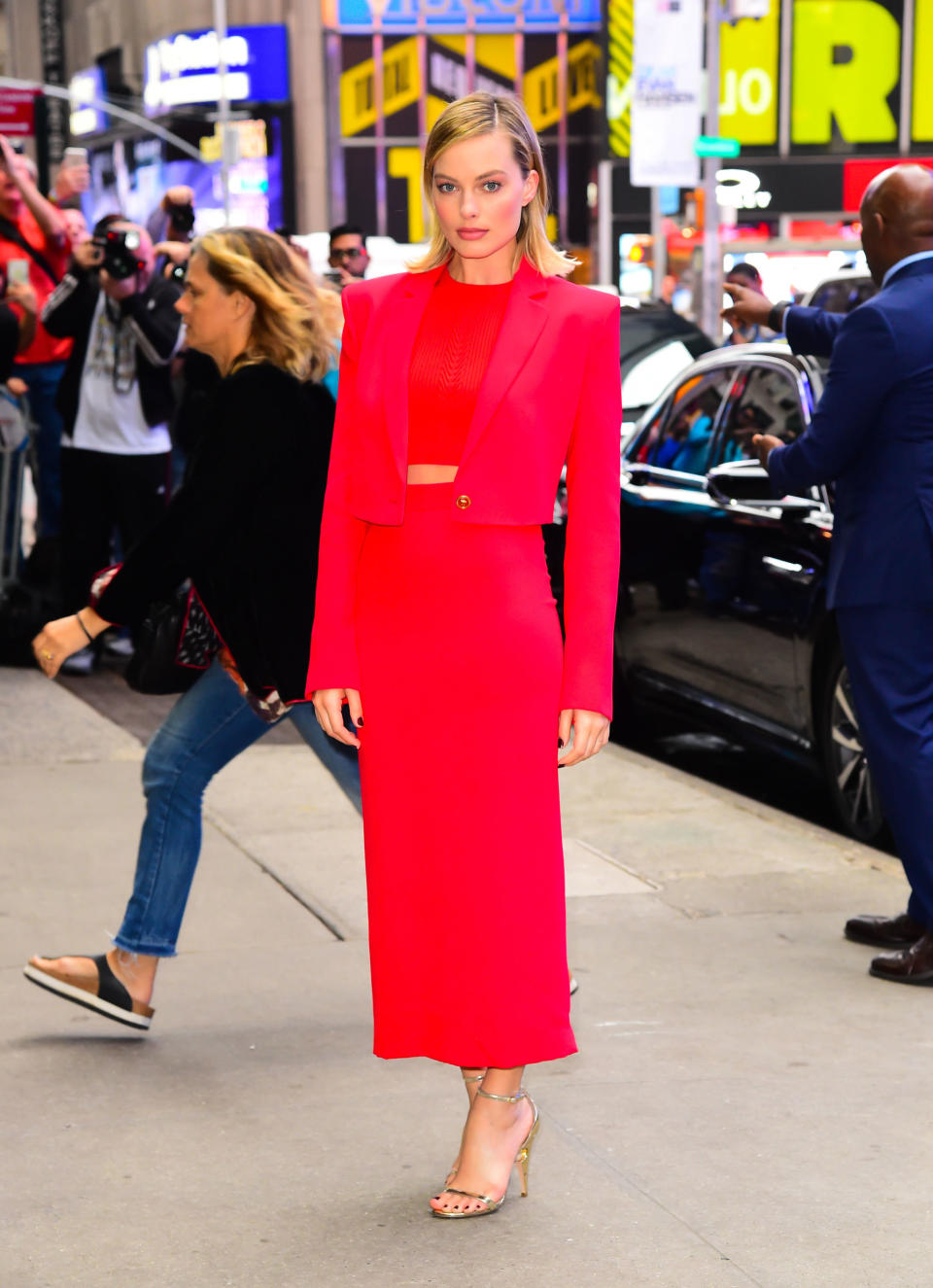 <p>Margot Robbie wore a red Versace skirt suit and Nicholas Kirkwood heels to appear on Good Morning America.</p>