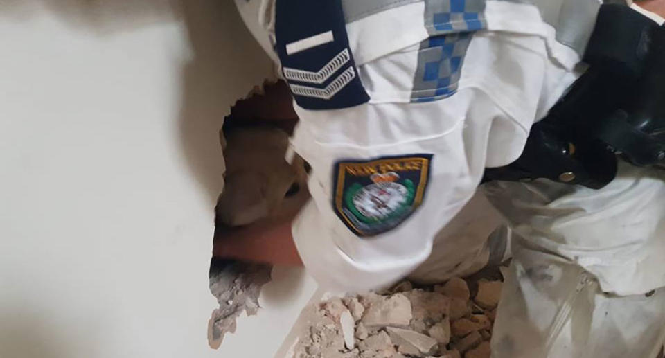 After about 30 minutes, officers were able to pull him through a hole in the wall. Source: NSW Police