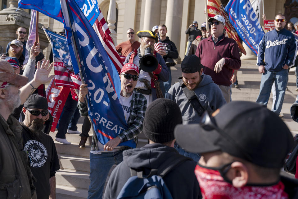 Trump supporters demonstrating the election results are confronted by counter protesters at the State Capitol in Lansing, Mich., Saturday, Nov. 7, 2020. Democrat Joe Biden defeated President Donald Trump to become the 46th president of the United States on Saturday, positioning himself to lead a nation gripped by the historic pandemic and a confluence of economic and social turmoil. (AP Photo/David Goldman)