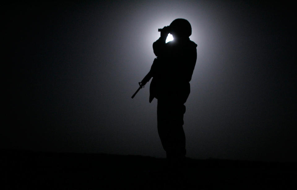 <p>A Marine from the 3rd Battalion, Fourth Marines scans the horizon with night vision goggles while silouetted by the moon during midnight patrol around Camp Mercury, the former Camp Abu Ghraib, June 23, 2005 in Anbar province, Iraq. Marines from the 3/4 embark on risky night patrols around their base in one of Iraq’s most dangerous zones to prevent attacks and keep insurgents at bay. (Photo by Chris Hondros/Getty Images) </p>