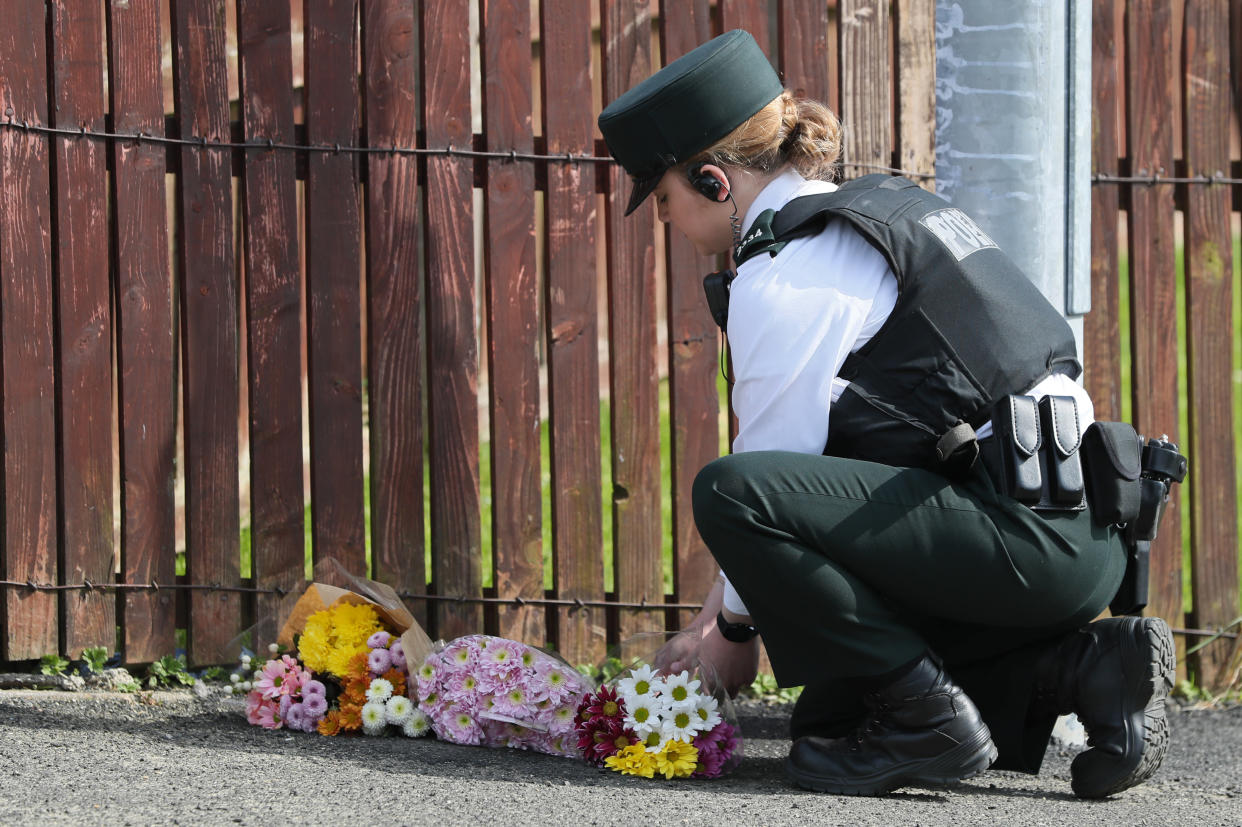 A police officer lays flowers at the scene in Londonderry, Northern Ireland, following the death of 29-year-old journalist Lyra McKee who was shot and killed when guns were fired and petrol bombs were thrown in what police are treating as a 'terrorist incident'. (Photo by Brian Lawless/PA Images via Getty Images)