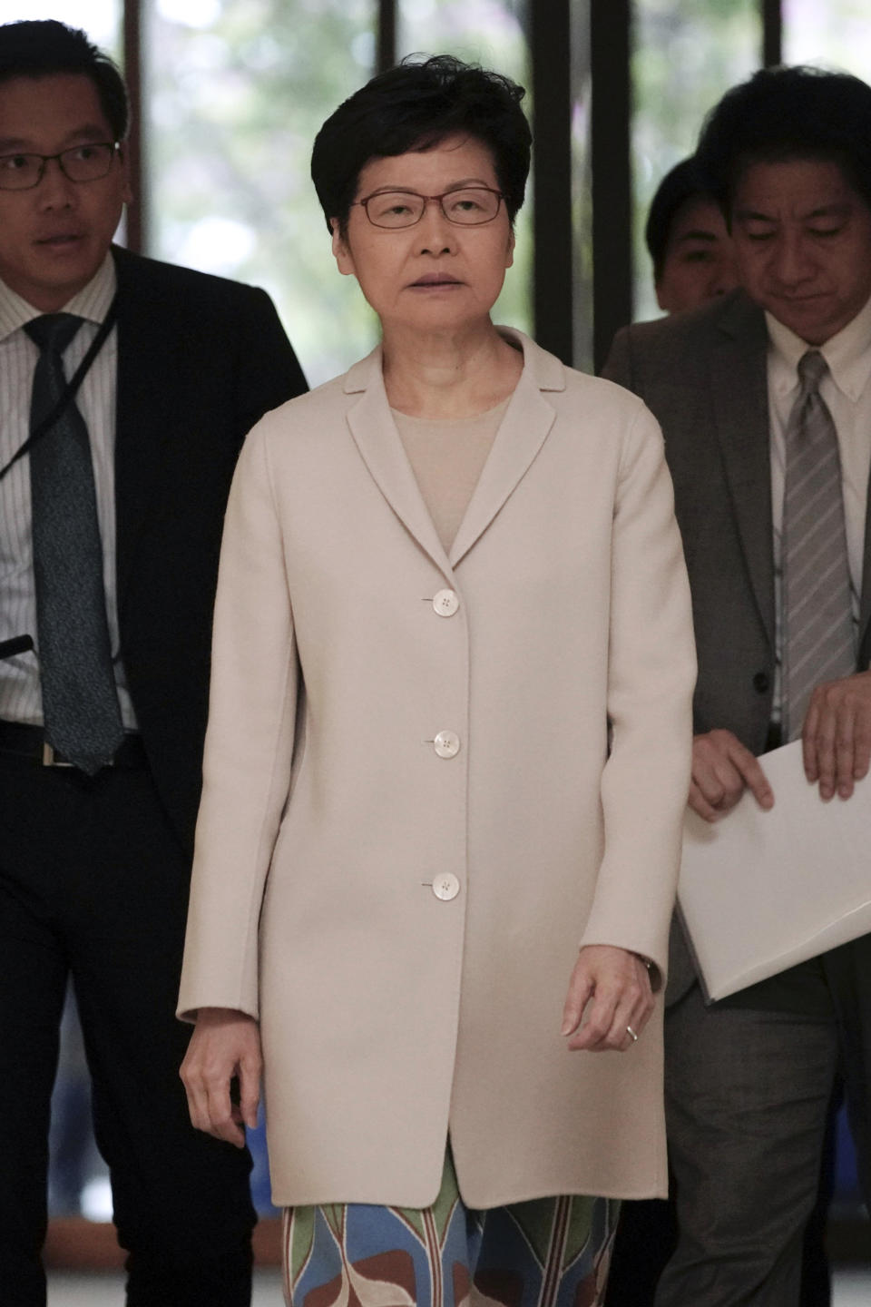 Hong Kong Chief Executive Carrie Lam, center, arrives for a press conference in Hong Kong, Tuesday, Nov. 26, 2019. Lam has refused to offer any concessions to anti-government protesters after a local election setback. (AP Photo/Vincent Yu)
