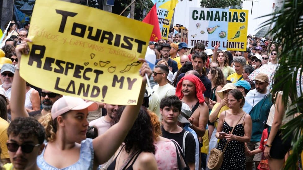 Protesters in Santa Cruz de Tenerife hold placards against mass tourism in Spain's Canary Islands. Photo: 20 April 2024