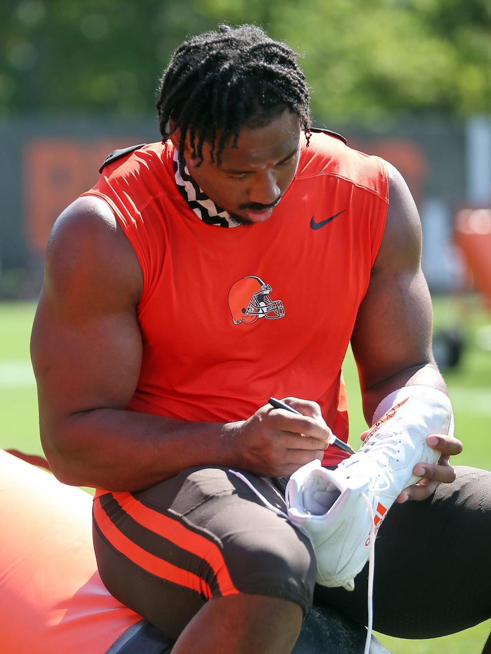 Cleveland Browns defensive end Myles Garrett signs his cleats after the NFL football team's football training camp in Berea on Tuesday.