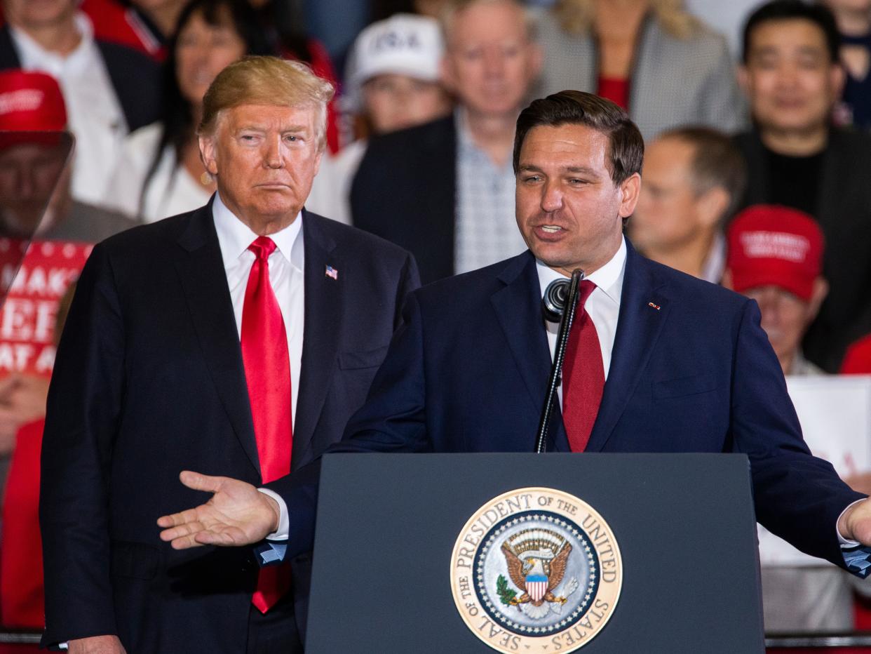 Florida Republican gubernatorial candidate Ron DeSantis speaks with U.S. President Donald Trump at a campaign rally at the Pensacola International Airport on November 3, 2018 in Pensacola, Florida