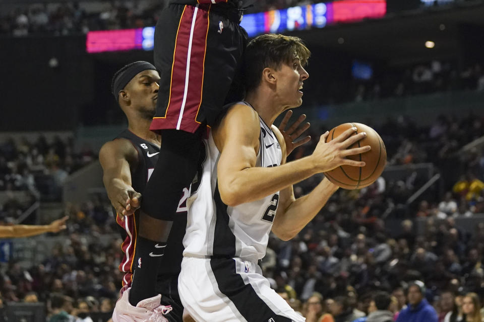 San Antonio Spurs' Jakob Poeltl goes up for a shot against Miami Heat's Victor Oladipo, during the second half of an NBA basketball game, at the Mexico Arena in Mexico City, Saturday, Dec. 17, 2022. (AP Photo/Fernando Llano)