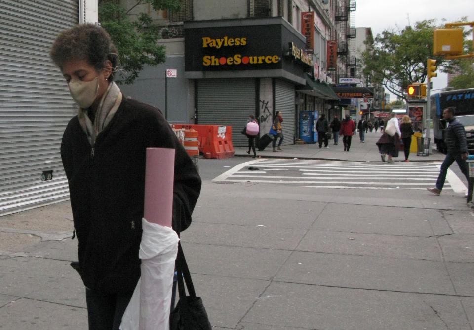 A pedestrian, wearing a mask, walks near the apartment building of Dr. Craig Spencer on October 24, 2014 in New York.