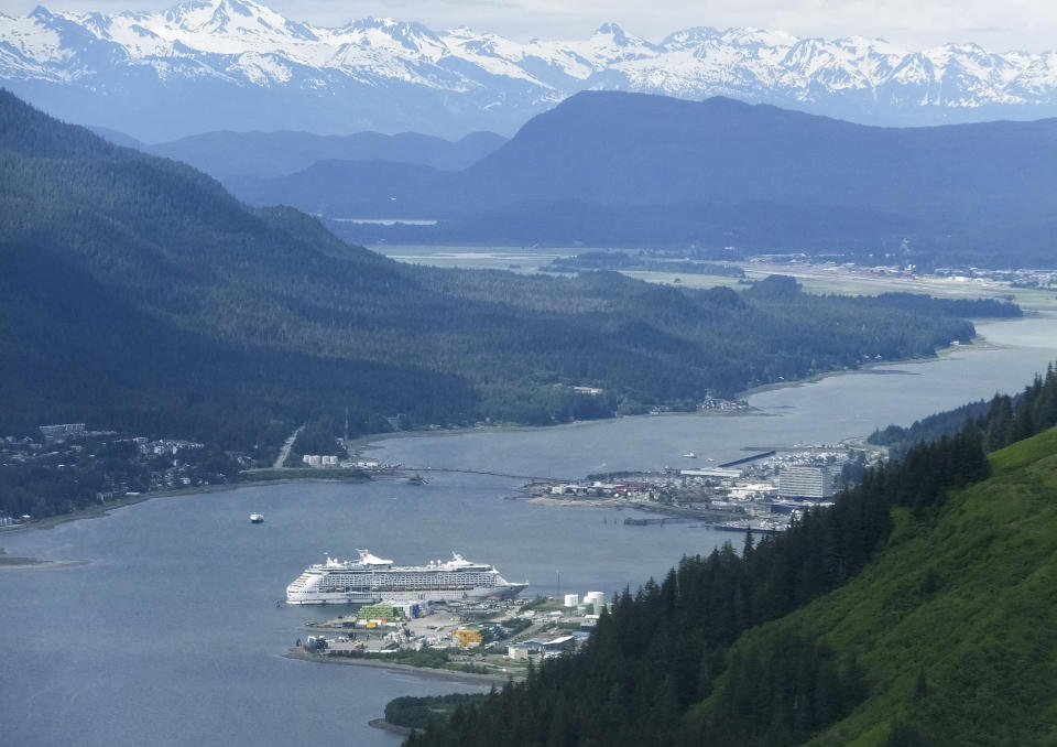 FILE - A cruise ship sits docked near downtown Juneau, Alaska, Sunday, June 4, 2017. A new agreement between Alaska's capital city and major cruise lines seeks to cap the daily number of cruise ship passengers arriving in Juneau starting in 2026, but a critic of the cruise industry says the planned limits don't go far enough. (AP Photo/Becky Bohrer, File)