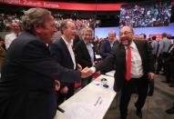 German Chancellor candidate Martin Schulz of the Social Democratic party (SPD) shakes hands with former German Chancellor Gerhard Schroeder, next to former SPD leader Franz Muentefering, as he arrives at the party convention in Dortmund, Germany, June 25, 2017. REUTERS/Wolfgang Rattay