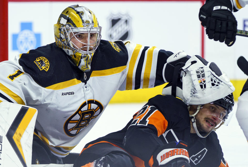 FILE - Boston Bruins' Jeremy Swayman, left, pushes Philadelphia Flyers' Scott Laughton, right, away during an NHL hockey game, Sunday, April 9, 2023, in Philadelphia. Boston Bruins goaltender Jeremy Swayman has been awarded $3.475 million through arbitration on a contract for next season, the team announced. A judge passed down his ruling Tuesday, Aug. 1, 2023 after a hearing Sunday. (AP Photo/Chris Szagola, File)